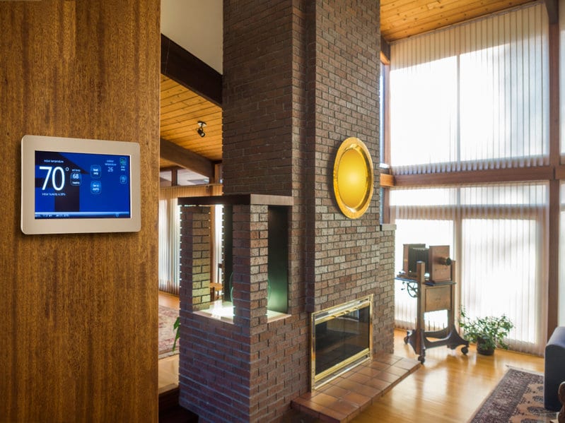 Smart thermostat on wall in modern living room.