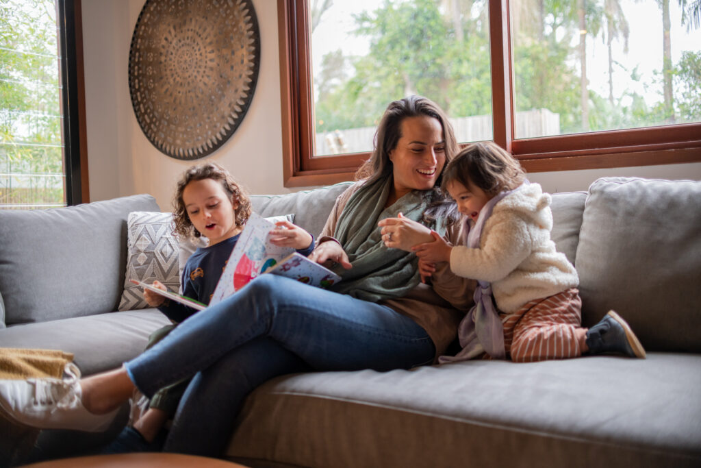 A happy family on a couch, reading and laughing